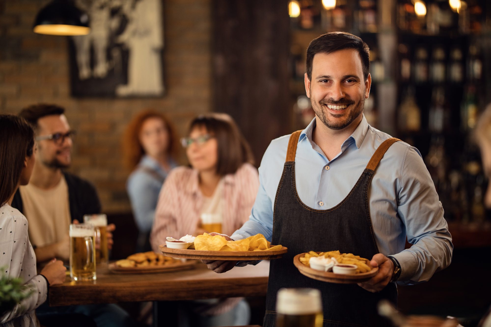 Smiling waiter serving food in a restaurant